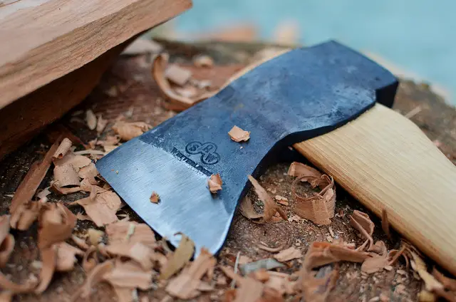 using a sharp axe to cut wood